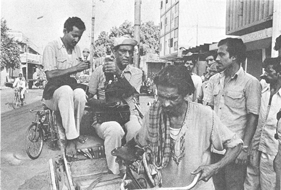 সাইকেল রিক্সাতে ক্যামেরা হাতে পরিচালক।