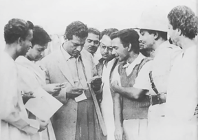 দেবী (১৯৬০) ছবির আউটডোরে শুটিং ইউনিট নিয়ে সত্যজিৎ। বাঁ-দিক থেকে সৌমিত্র চট্টোপাধ্যায়, সত্যজিৎ রায়, ভানু ঘোষ, সুব্রত মিত্র, বংশী চন্দ্রগুপ্ত এবং অন্যান্যরা‌।