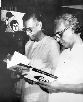 চ্যাপলিনের জন্মশতবর্ষ অনুষ্ঠানে স্মারক পুস্তিকা দেখছেন সত্যজিৎ রায় ও মৃণাল সেন (১৯৮৯)