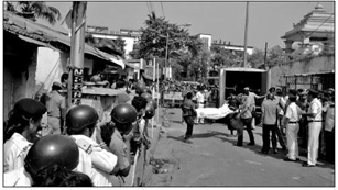 দোকান থেকে বের করে নিয়ে যাওয়া হচ্ছে ডেড বডি। পাশে লাশ পচা গন্ধে নাকে রুমাল পুলিশ—জনতার